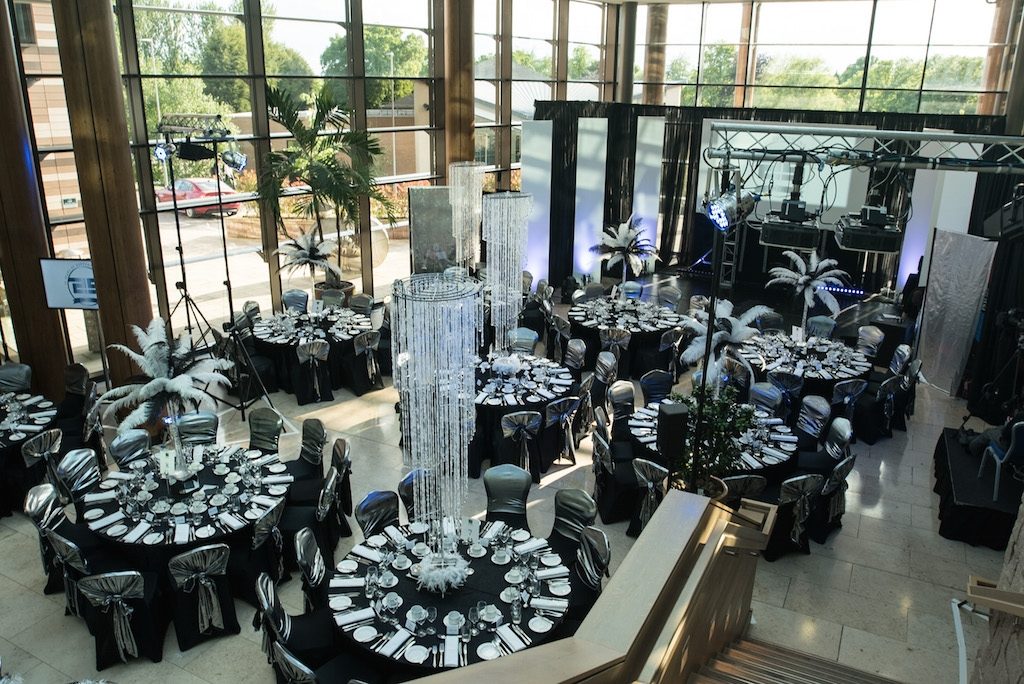 Black and white table decorations with hanging chandelier table centres and black and white feather centrepieces