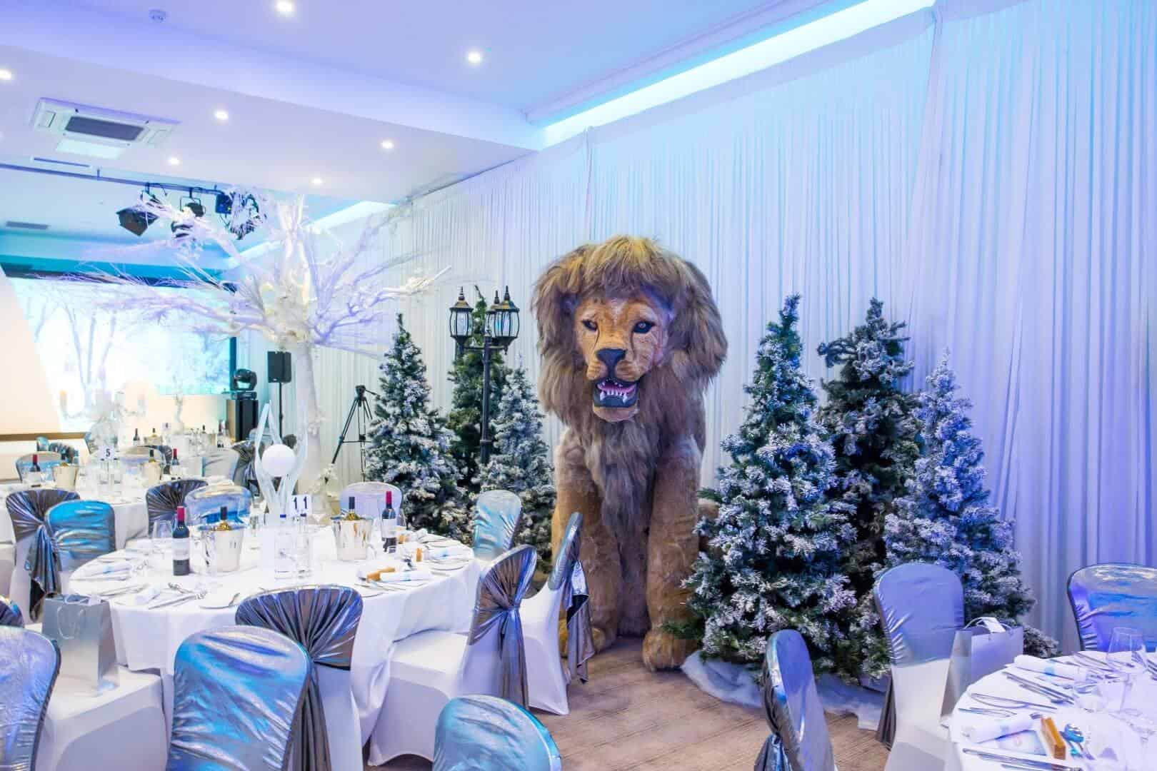 Large lion prop with Christmas trees and white draping on walls