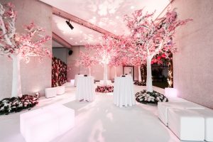 White room with white seats and faux pink cherry blossom trees as props