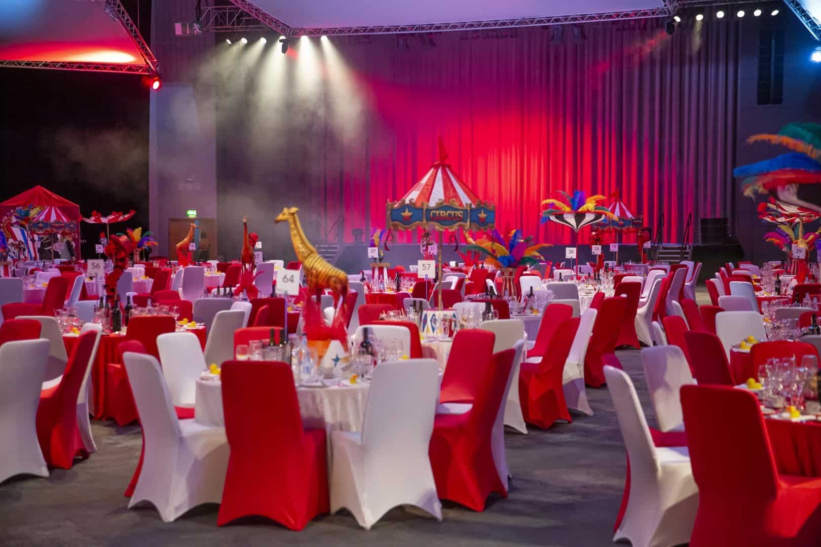 Circus themed event with red and white chairs and table and props