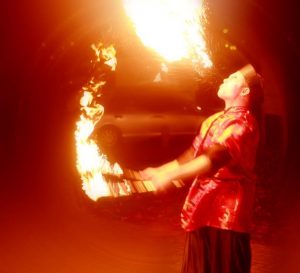 Man wearing red robe fire breathing