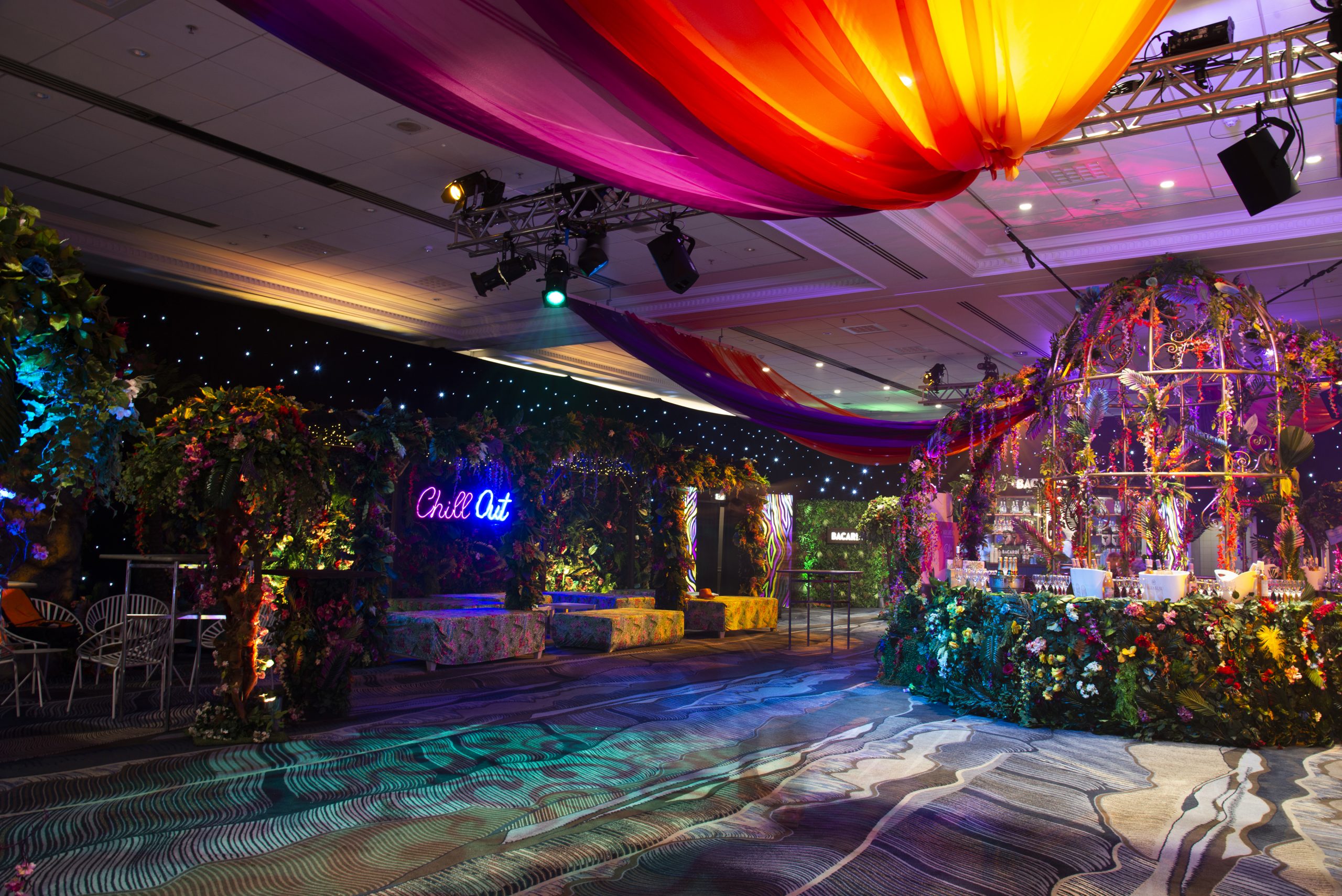 neon jungle carnival colourful exhibition room styling floral foliage birdcage performers