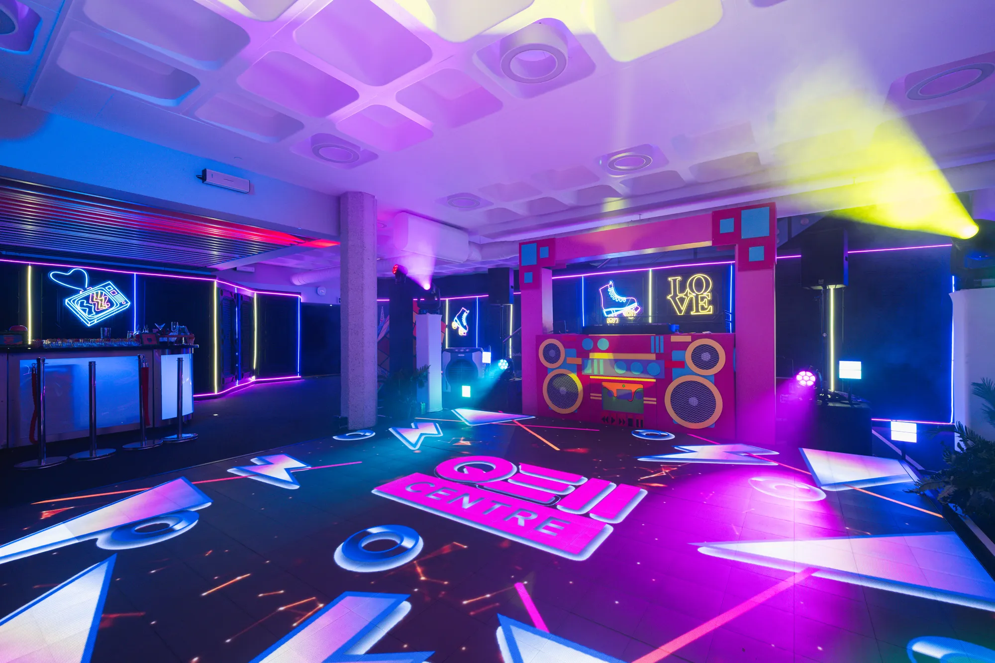 Neon Roller Skate & Love Signs Over Branded DJ Booth