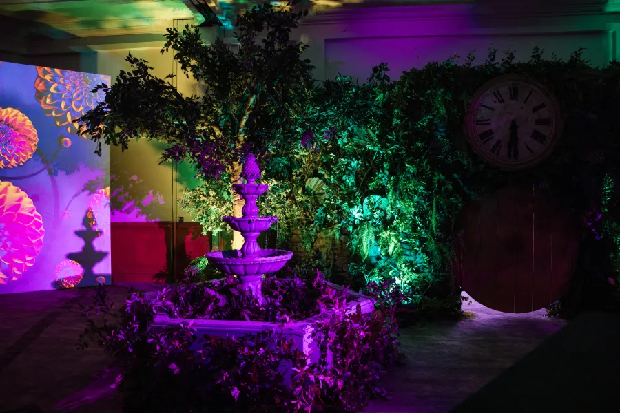 Fountain & Oversized Clock Beneath Lit Foliage