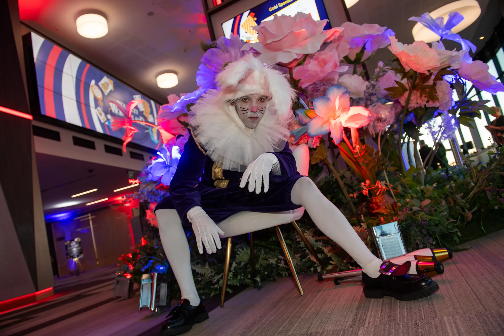 White Rabbit Performer Against an Oversized Flower Wall