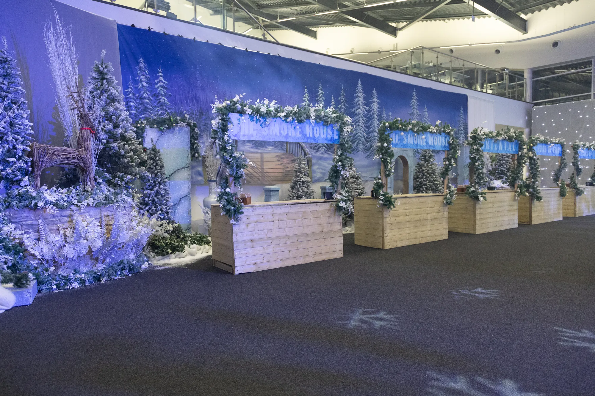 Winter Market Food Stalls Along a Snowy Pine Backdrop